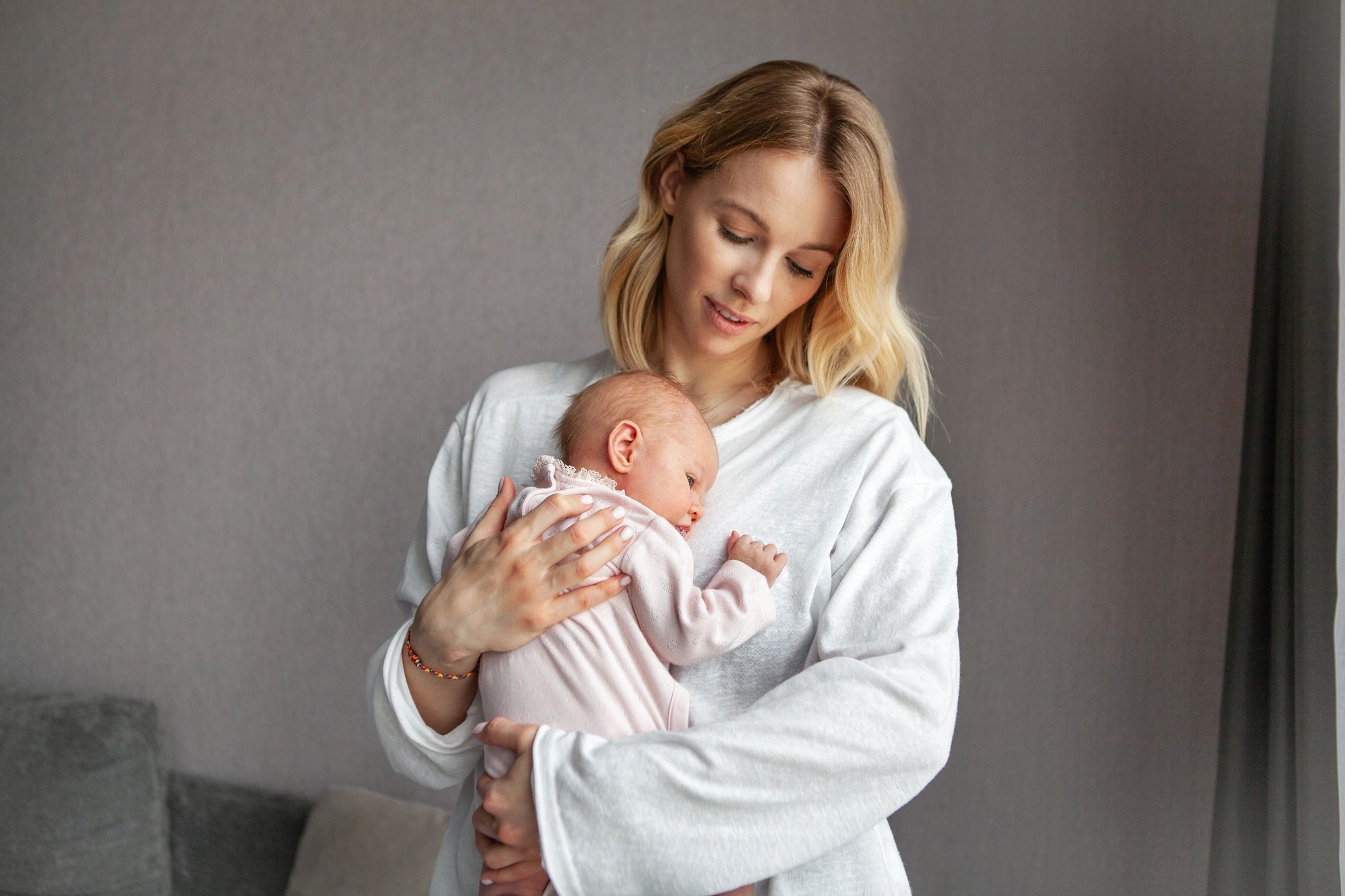 Mother holding a newborn in soft natural light